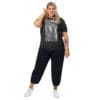 Woman in dark gray graphic tee and pants.