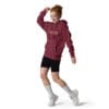 Woman wearing a maroon hoodie and shorts.