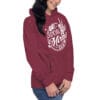 Woman wearing a burgundy hoodie with slogan.