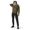 Woman wearing olive hoodie and black jeans.