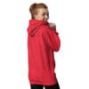 Smiling woman in a red hoodie, turned away.