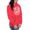 Woman wearing a red hoodie with graphic design.